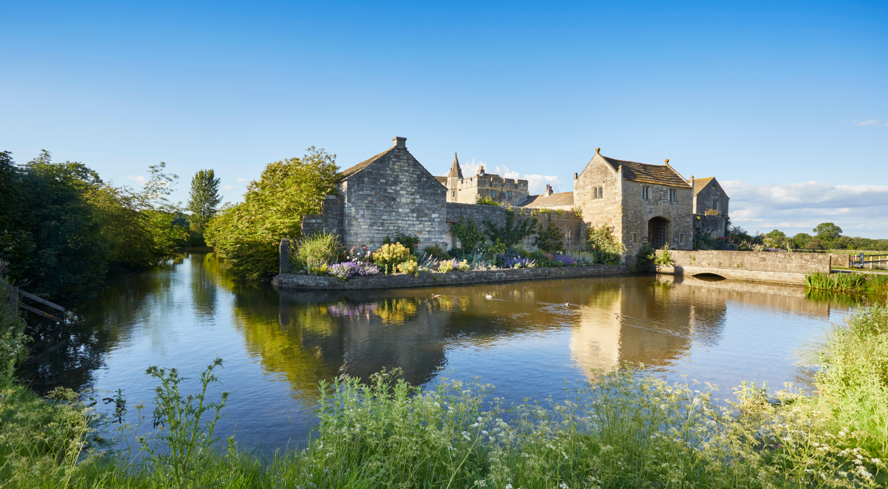 View Across The Water of Stone Buildings - Chartford Homes